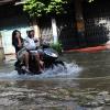 Motorbike Rider Navigates a Flooded Street