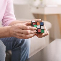 Old woman holding Rubik cube