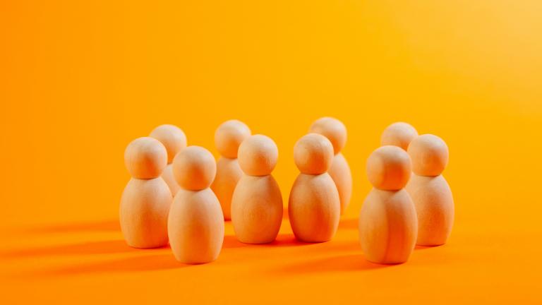 group of wooden figures, representing people, standing in row