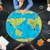 people collaborating around drawing of a globe