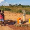 Local African children pumping drinking water at well