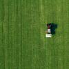 Agricultural tractor fertilizing wheat crop field with NPK