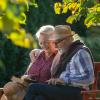 Senior couple reading book in park