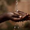 Social Issues: Water Pouring in African Child`s Hands