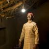 Indian man looking at light bulb in his house