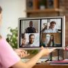 Women sitting at desk looking at zoom call in progress on computer screen