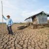Man standing on cracked soil of a dried up lake