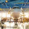 Aircraft in the aviation industrial hangar on maintenance, outside the gate bright light