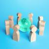 Circle of wooden figures surrounds the Earth globe. Global world communication concept. Science education, diplomacy, business.