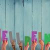 Diverse hands holding the letters spelling the word Wellbeing
