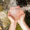 Hands catching clean water from a natural source