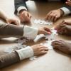 Diverse people working together to assemble puzzle
