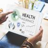 Woman holding tablet showing health insurance concept