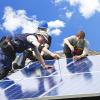 Technicians installing solar panels on a roof 