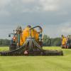 Agriculture, injecting of liquid manure with two tractors and yellow vulture spreader trailers