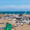 Plastic pollution on a beach with sea in background