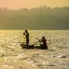 Fishermen casting a net in Lake Victoria at a bright sunset. Uganda