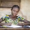 African school girl posing at a school desk with pen and paper 