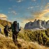 Group of friends with backpacks hiking in the mountains
