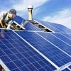 Man installing solar panels on the roof of a house
