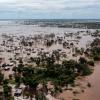 A big flood with trees and a rural African village flooded by dirty waters 