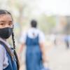 Portrait of an Asian girl wearins a face mask to protect against PM 2.5 dust and air pollution. 