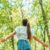 Woman breathing clean air in a green forest.