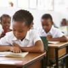 Schoolgirl reading at her desk in elementary school lesson
