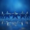 Five blue stars on a reflective surface signifying excellence