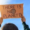 Boy holding a sign that reads `There is no planet B`