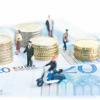 Miniature people on 20 Euro banknotes and Euro coins close-up 