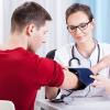 Doctor measuring blood pressure of young man 