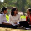 A group of Young Indian graduating college student studying with books and laptop at the campus ground in India. 