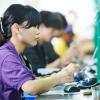 Female chinese worker testing production at line conveyor in china factory manufacturing 