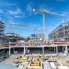 Large construction site with foundations, scaffolding and cranes.