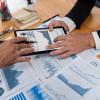 Analysts discussing financial data on digital dashboard