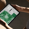 Person looking at tablet with green dashboard on screen