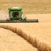 Farm machinery harvesting wheat in the fertile farm fields of Idaho. 