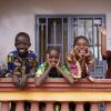African children greeting bypassers from a balcony