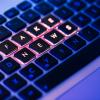 the phrase "fake news" illuminated on a computer keyboard