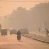 motorcycle and cars driving on a road high in airpollution